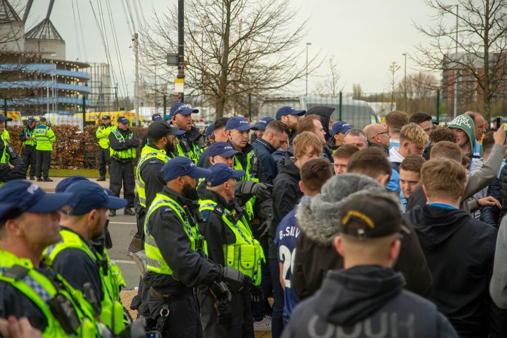 Police move the city fans back onto the grass after the team