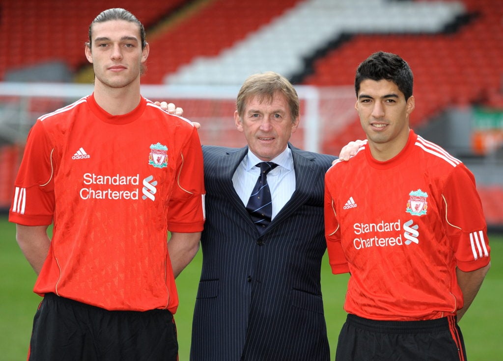 Liverpool manager Kenny Dalglish poses with their new signings Andy Carroll and Luis Suarez