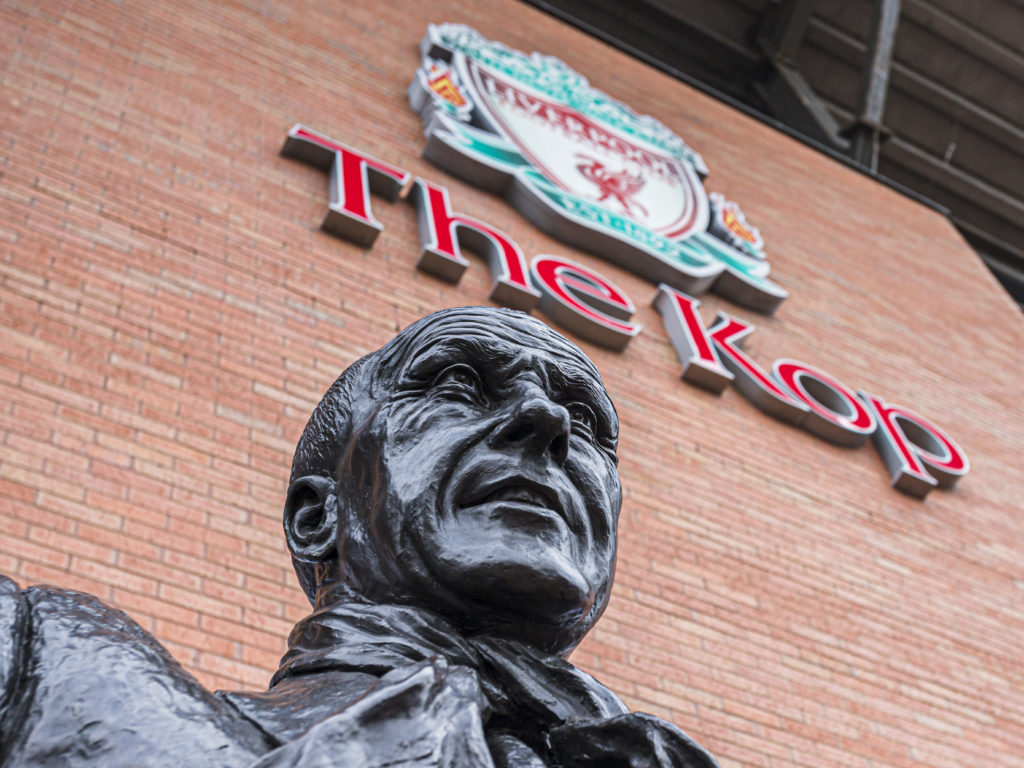 Looking up at the Bill Shankly statue outside The Kop stand at Anfield Stadium in Liverpool