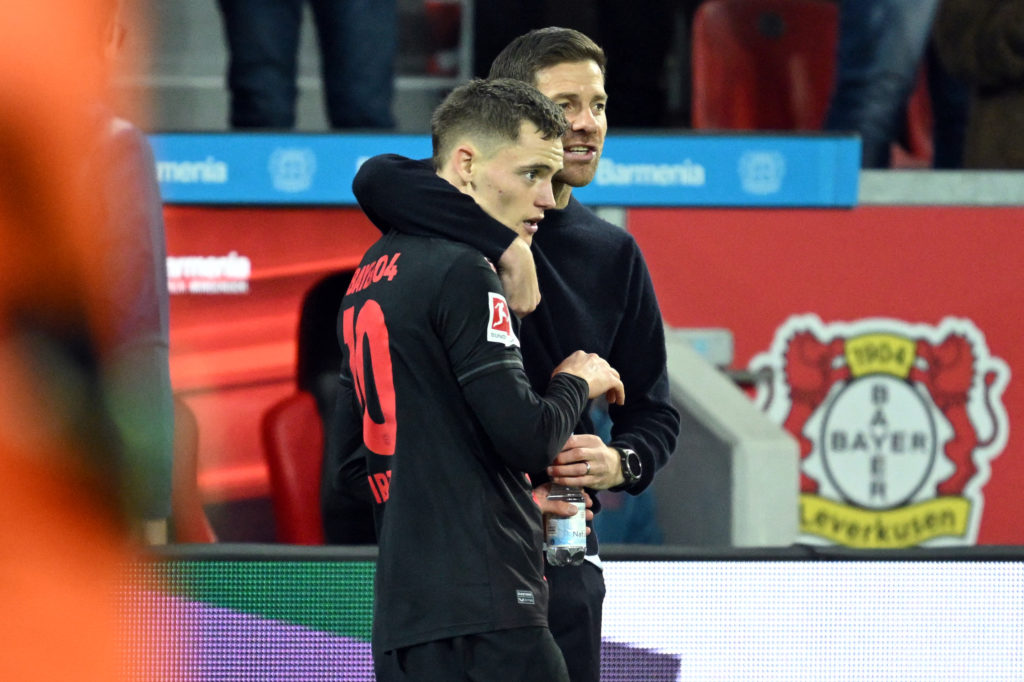 Bayer Leverkusen's German midfielder #10 Florian Wirtz (L) speaks with Bayer Leverkusen's Spanish coach Xabi Alonso during the German first division Bundesliga football match between Bayer 04 Leverkusen and SC Freiburg