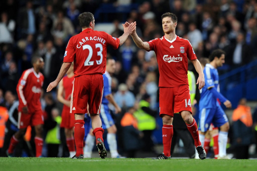 Jamie Carragher and Xabi Alonso high five after Liverpool's Premier League win over Chelsea at Stamford Bridge