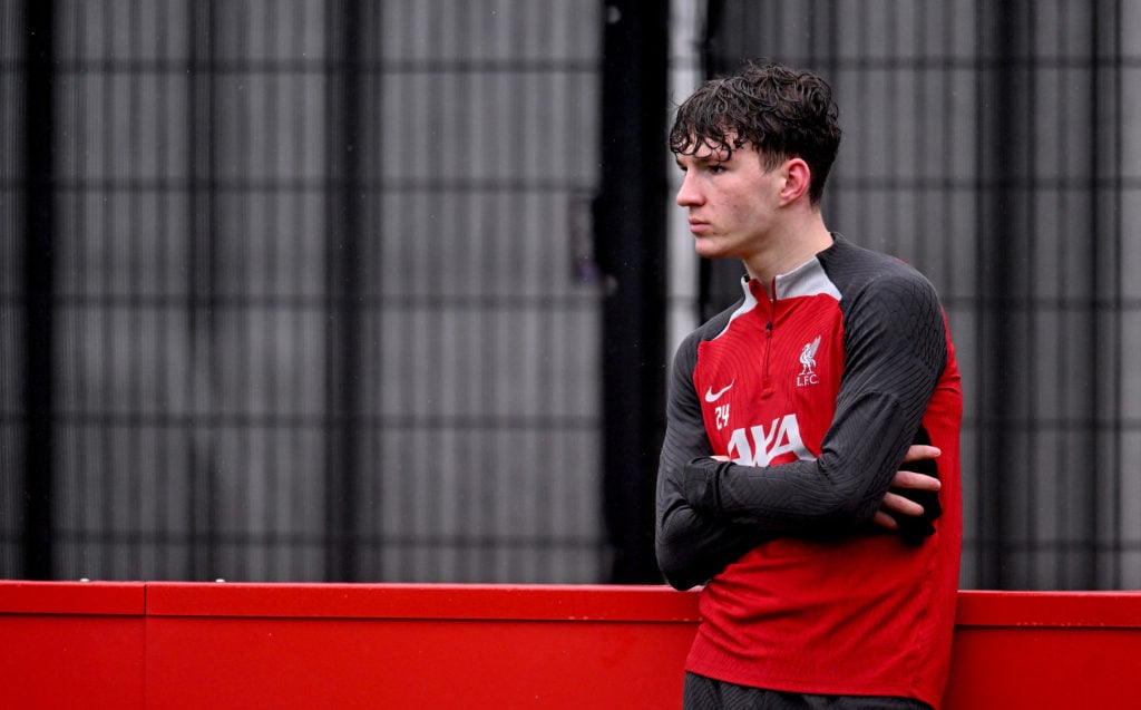 Lewis Koumas leans on the advertising hoardings during a Liverpool training session.