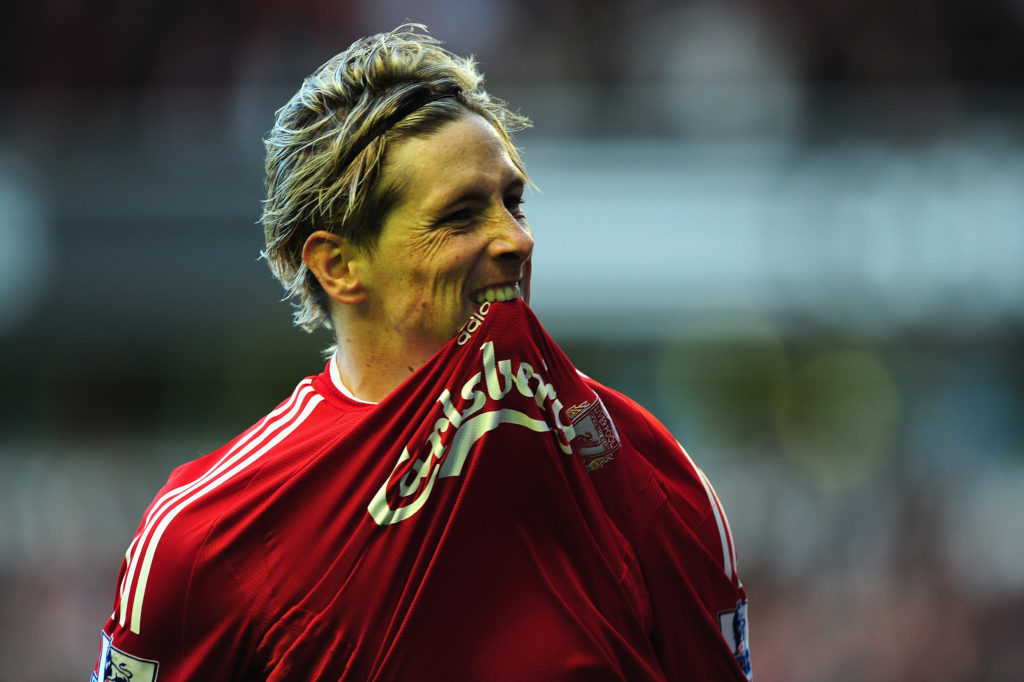 Fernando Torres bites his shirt in celebration after scoring for Liverpool against Manchester United.