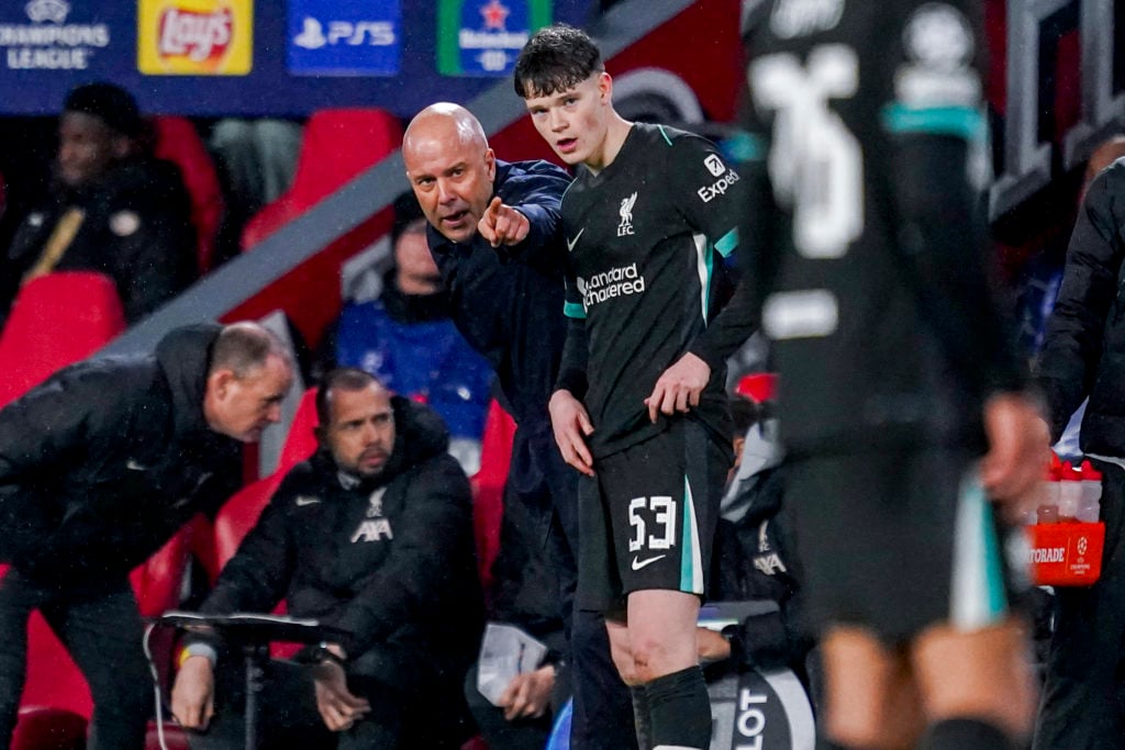 Arne Slot speaks to James McConnell during Liverpool's UEFA Champions League match against PSV Eindhoven.