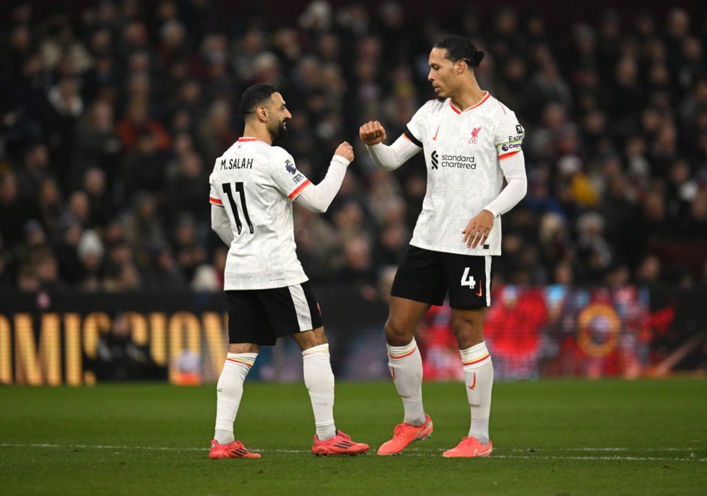 Virgil van Dijk and Mohamed Salah fist-bumping during a Premier League game between Liverpool and Aston Villa.