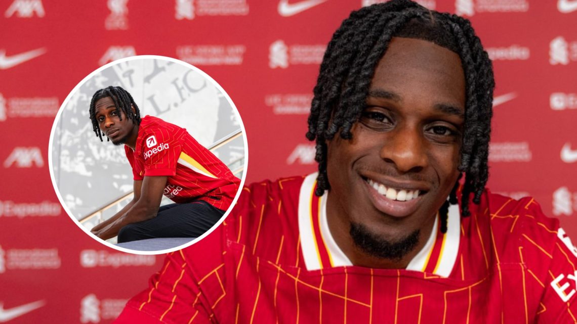 Jeremie Frimpong smiles and poses with a contract after joining Liverpool. Jeremie Frimpong poses while sitting after signing for Liverpool.
