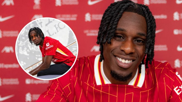 Jeremie Frimpong smiles and poses with a contract after joining Liverpool. Jeremie Frimpong poses while sitting after signing for Liverpool.