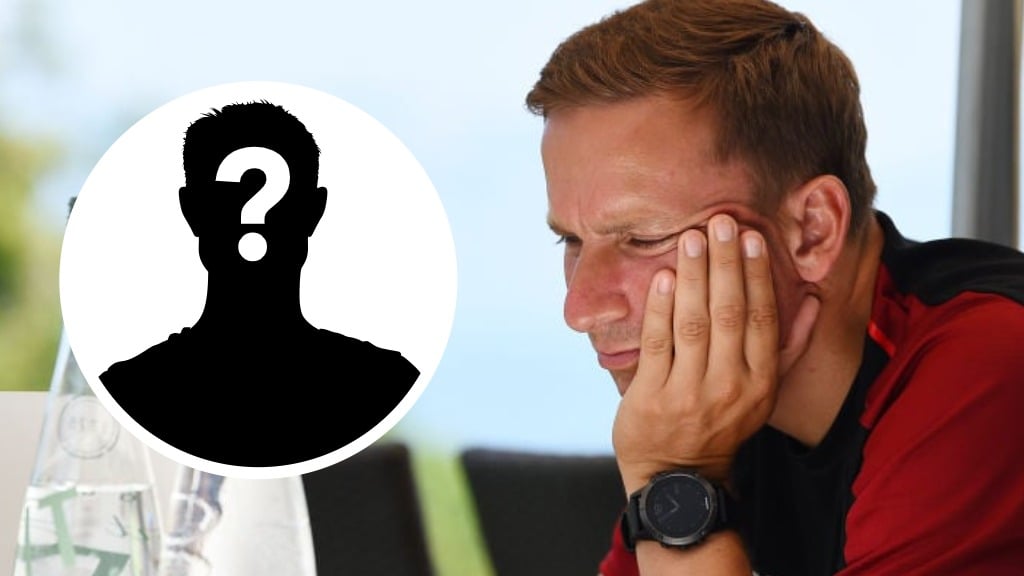 Liverpool assistant manager Pep Lijnders looks at a laptop during pre-season. Mystery player silhouette with question mark.