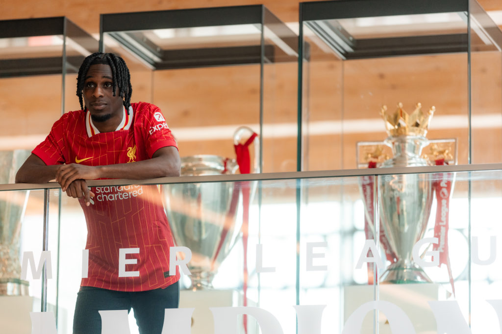 Jeremie Frimpong poses in front of the Premier League trophy during his unveiling as a new Liverpool signing.