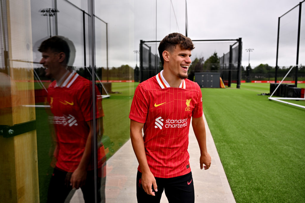 Milos Kerkez smiles as he walks out onto the Liverpool training pitches after signing for the Reds.
