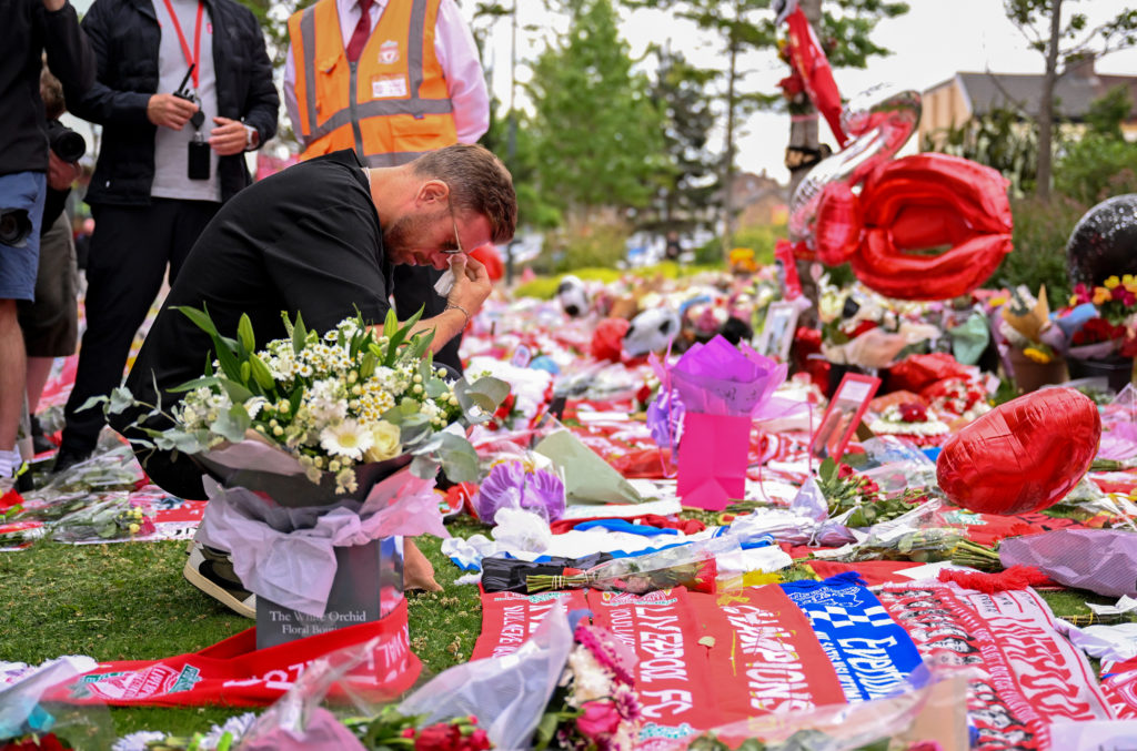 Jordan Henderson kneels as he pays tribute to late former Liverpool teammate Diogo Jota at Anfield following his death in a car accident.
