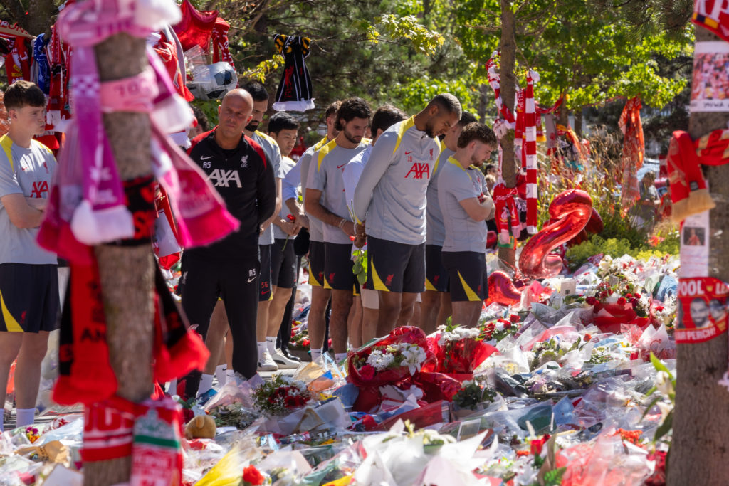 Liverpool players and Arne Slot stand after laying tributes at Diogo Jota's memorial at Anfield