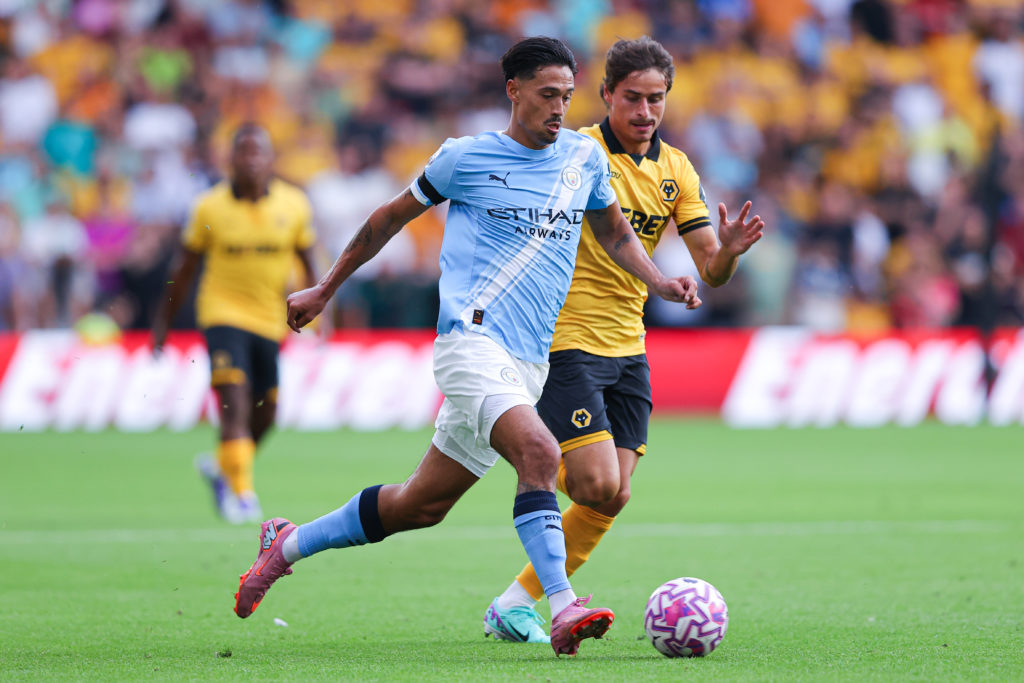 Tijjani Reijnders and Hugo Bueno battle for the ball during the Premier League match between Wolves and Manchester City at Molineux