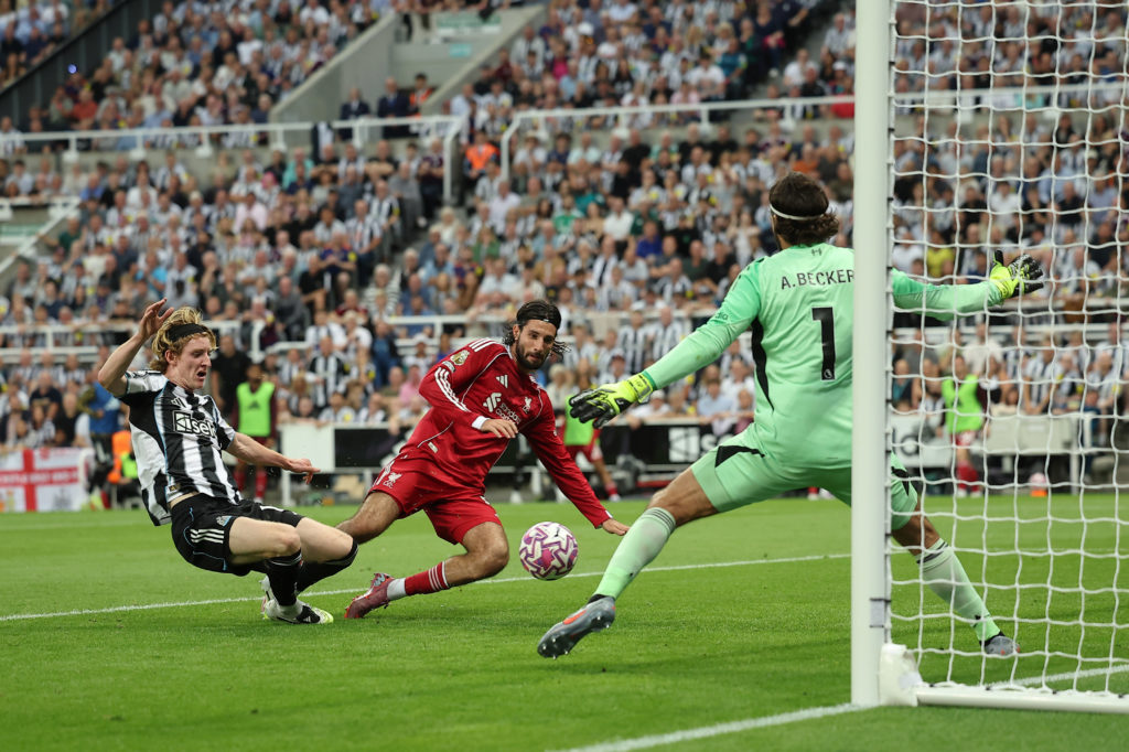 Anthony Gordon of Newcastle United is stopped by Dominik Szoboszlai of Liverpool and Liverpool goalkeeper Alisson Becker during the Premier League match between Newcastle United and Liverpool at St James' Park