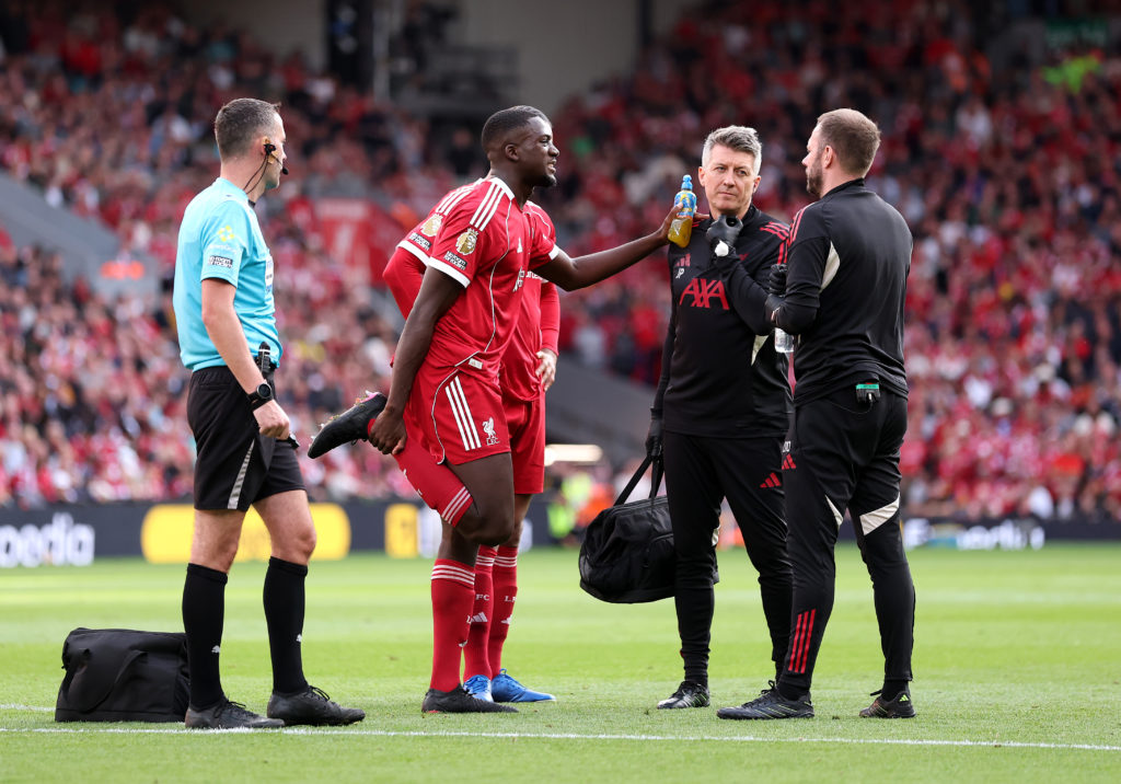 Ibrahima Konate is treated by Liverpool's medical team during the Premier League match against Arsenal at Anfield.