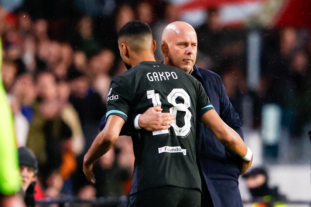 Arne Slot greets Cody Gakpo after substituting him during Liverpool's UEFA Champions League match against PSV Eindhoven.