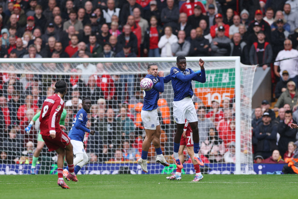 Jack Grealish and Thierno Barry of Everton form a wall to block a free kick taken by Dominik Szoboszlai of Liverpool during the Premier League match between Liverpool and Everton at Anfield.