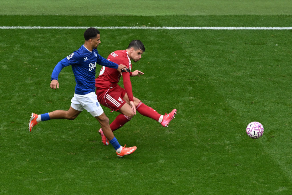 Milos Kerkez of Liverpool crosses the ball whilst under pressure from Iliman Ndiaye of Everton during the Premier League match between Liverpool and Everton at Anfield.