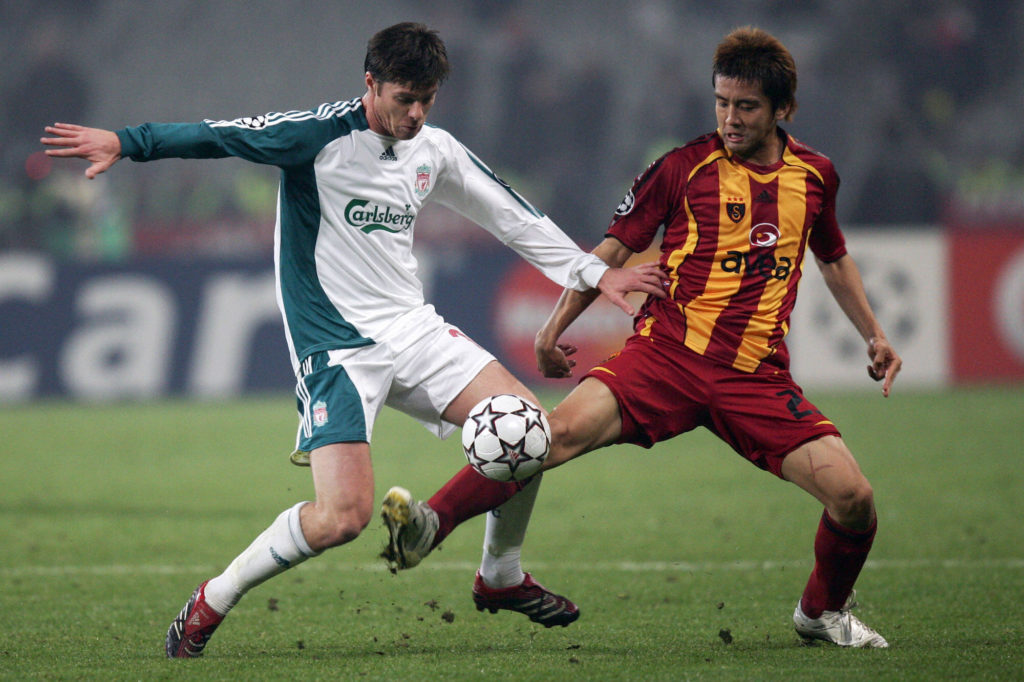 Xabi Alonso and Junichi Inamoto challenge for the ball during Liverpool's match against Galatasaray in the UEFA Champions League.