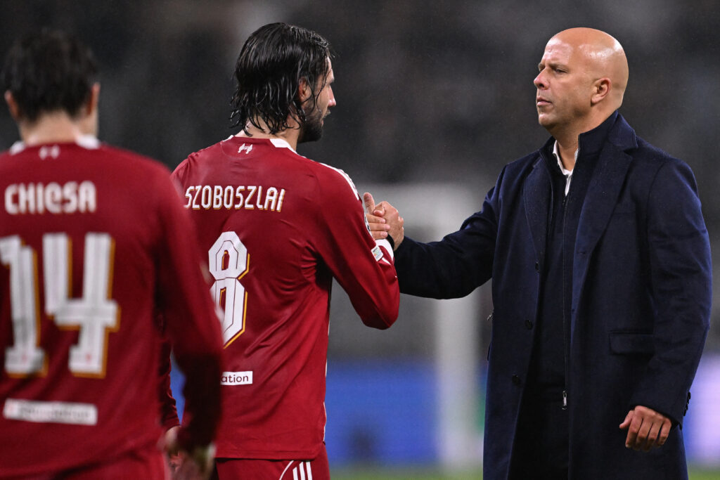 Arne Slot clasps hands with Dominik Szoboszlai at the end of Liverpool's UEFA Champions League match against Eintracht Frankfurt at Deutsche Bank Park.
