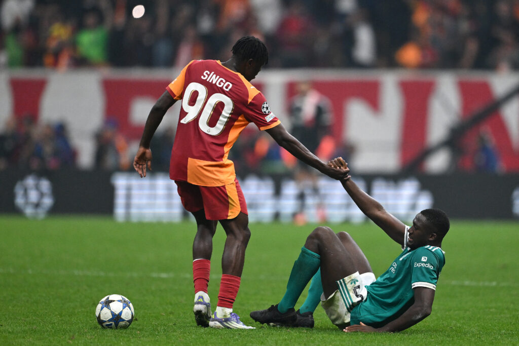 Wilfried Singo helps Ibrahima Konate off the ground during Galatasaray's UEFA Champions League match against Liverpool.