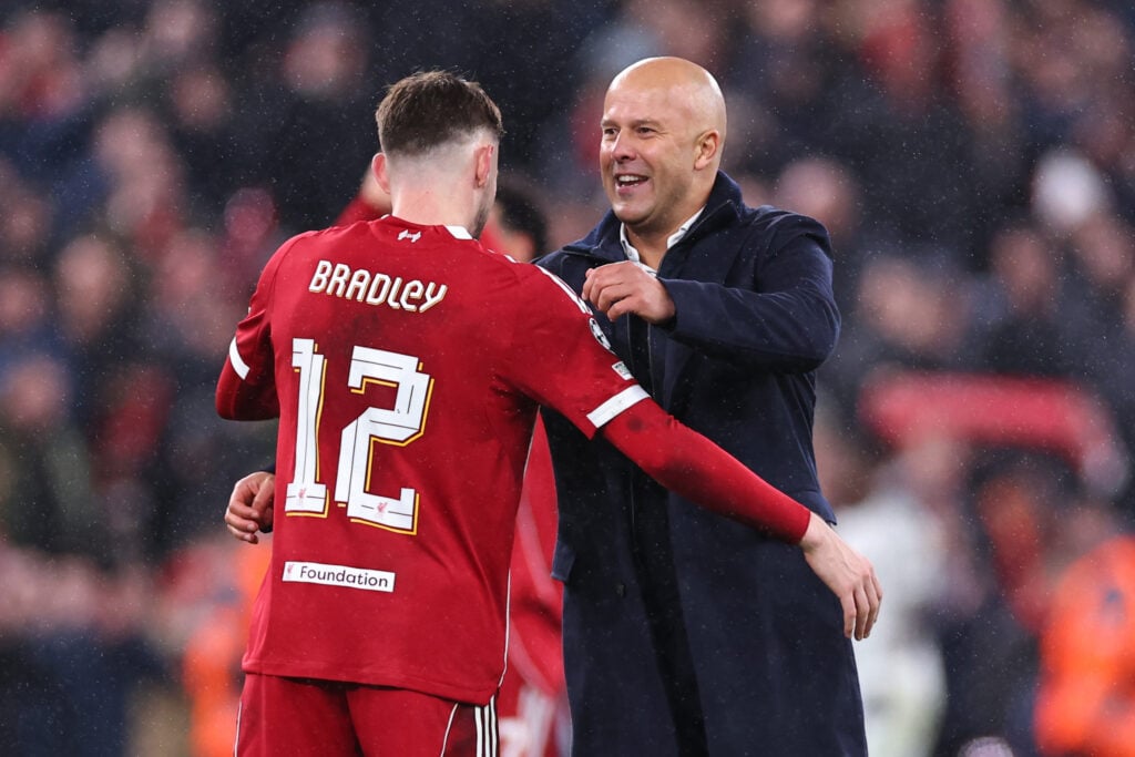Conor Bradley of Liverpool celebrates with Arne Slot manager / head coach of Liverpool at full time following the 1-0 victory during the UEFA Champions League 2025/26 League Phase MD4 match between Liverpool FC and Real Madrid C.F. at Anfield