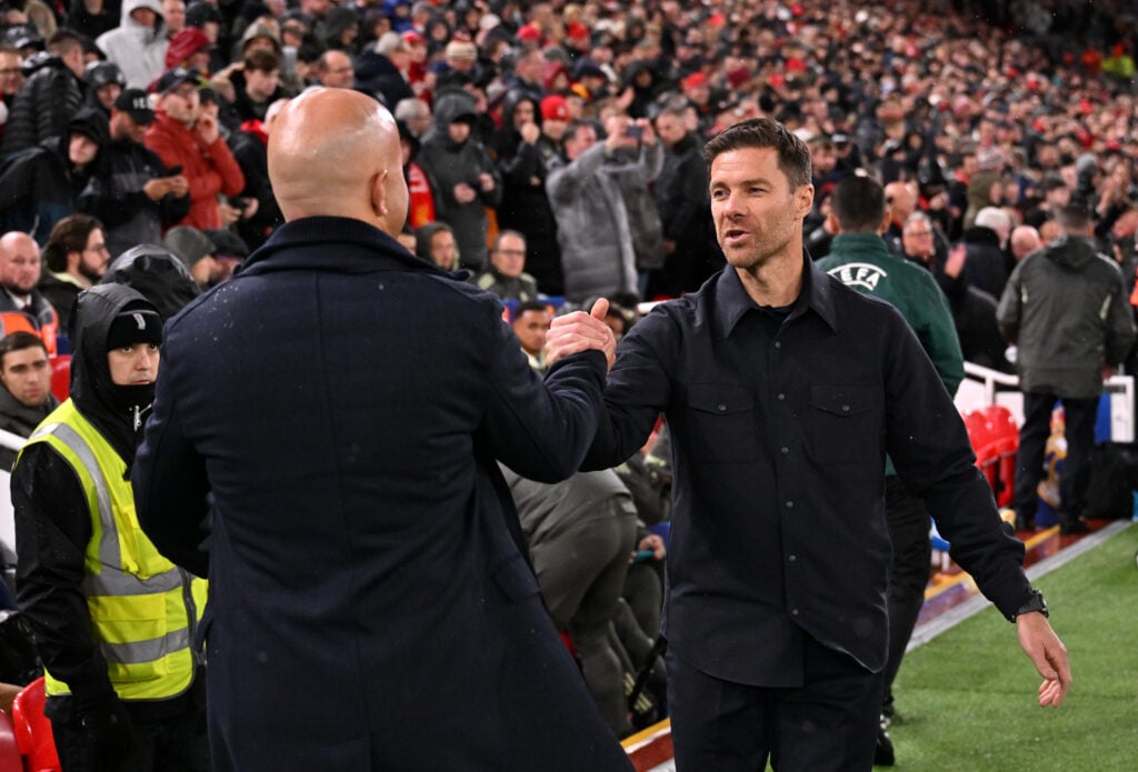 Xabi Alonso and Arne Slot clasp hands ahead of Liverpool's UEFA Champions League match against Real Madrid at Anfield.