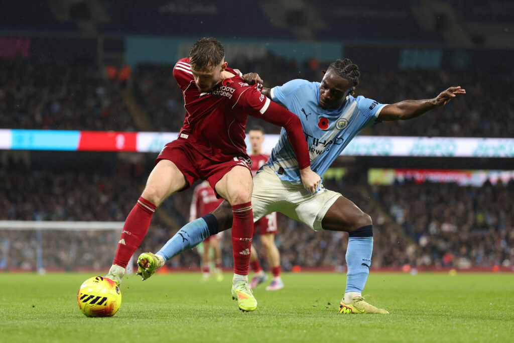 Conor Bradley of Liverpool is challenged by Jeremy Doku of Manchester City during the Premier League match between Manchester City and Liverpool at Etihad Stadium