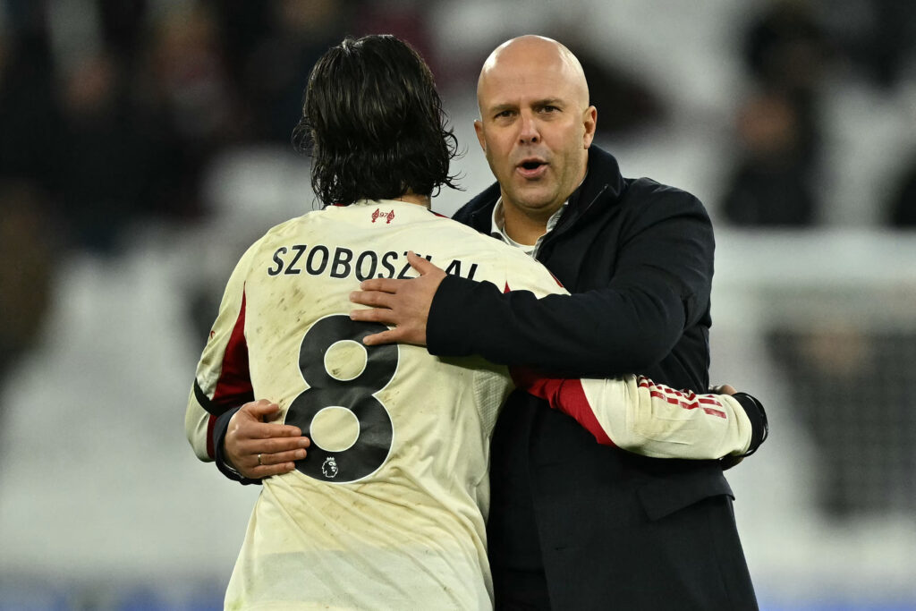 Liverpool's Dutch manager Arne Slot (R) embraces Liverpool's Hungarian midfielder #08 Dominik Szoboszlai (L) on the pitch after the English Premier League football match between West Ham United and Liverpool
