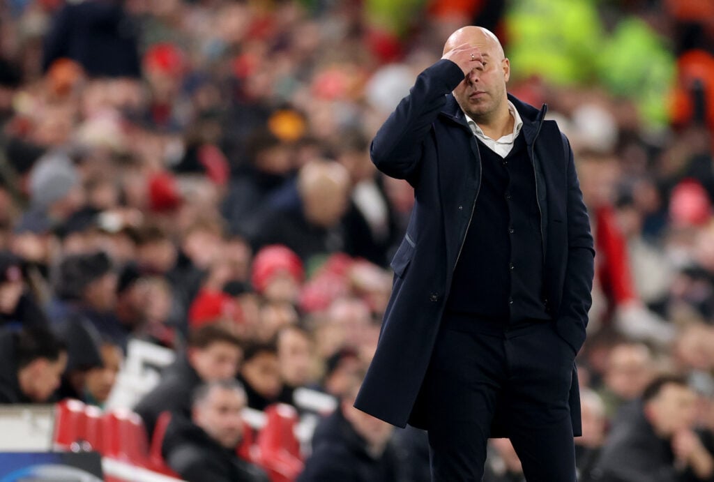 Arne Slot puts his hand over his face during Liverpool's UEFA Champions League loss against PSV Eindhoven at Anfield.