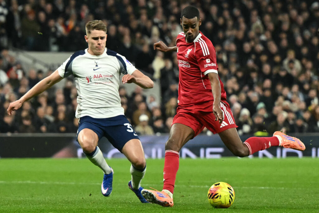 Liverpool's Swedish striker #09 Alexander Isak (R) shoots to score the opening goal for 0-1 as Tottenham Hotspur's Dutch defender #37 Micky van de Ven (L) challenges during the English Premier League football match between Tottenham Hotspur and Liverpool at the Tottenham Hotspur Stadium