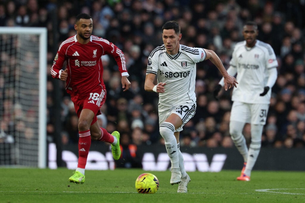 Fulham's Serbian midfielder #20 Sasa Lukic (R) runs with the ball as Liverpool's Dutch striker #18 Cody Gakpo (L) chases during the English Premier League football match between Fulham and Liverpool at Craven Cottage