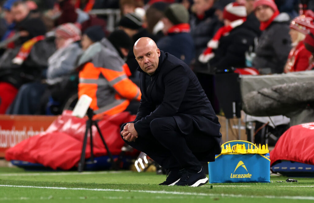 Arne Slot watches from his haunches during Liverpool's Premier League matches against Leeds United at Anfield.