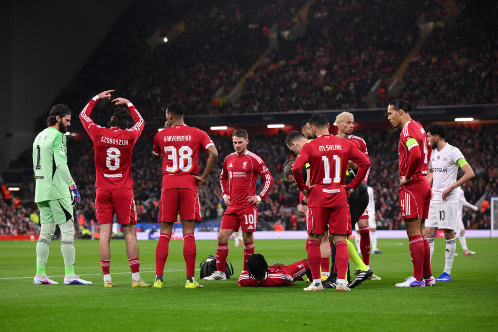 Liverpool players surround Jeremie Frimpong as he lays injured on the Anfield pitch during the UEFA Champions League match against Qarabag